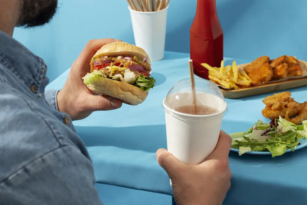 mężczyzna je żywność typu fast food