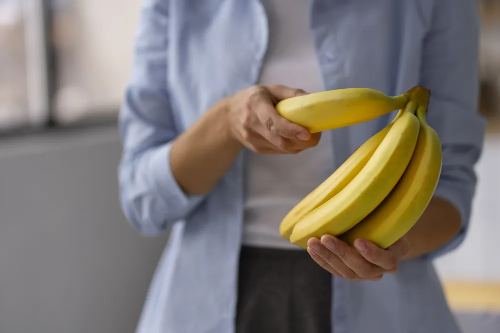 kobieta trzyma dojrzałe banany