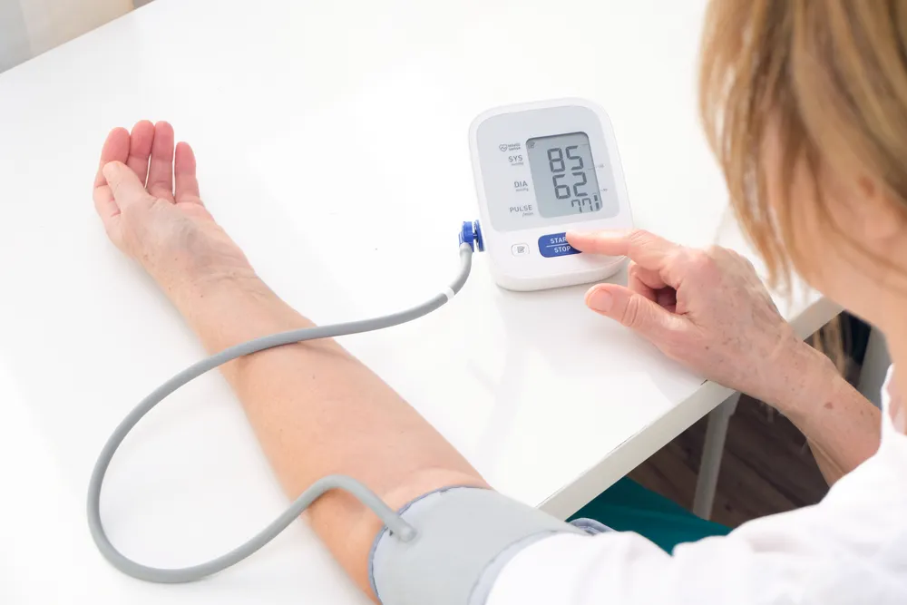 kobieta mierzy ciśnienie ciśnieniomierzem