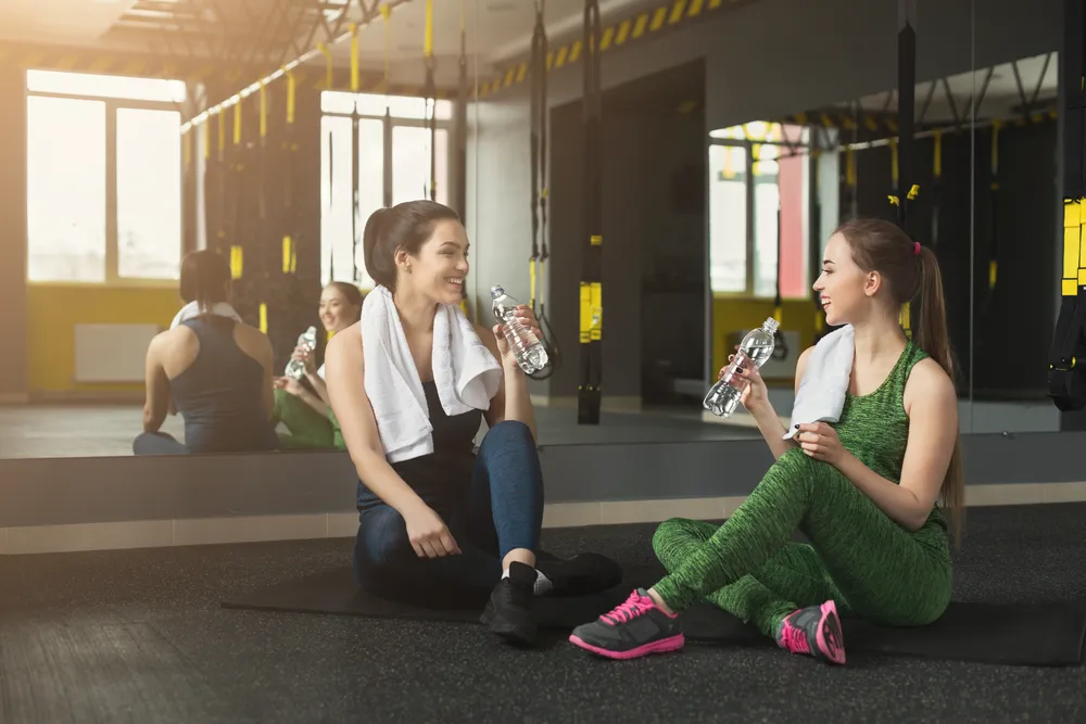 dwie kobiety po treningu piją wodę