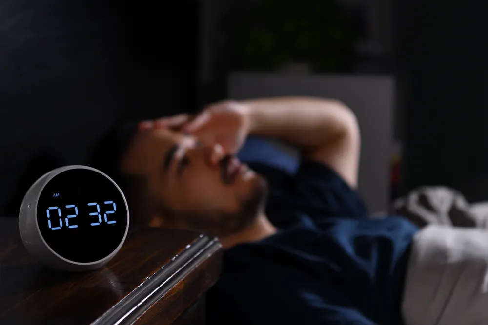 mężczyzna ma zaburzenia snu przez częste zmiany stref czasowych