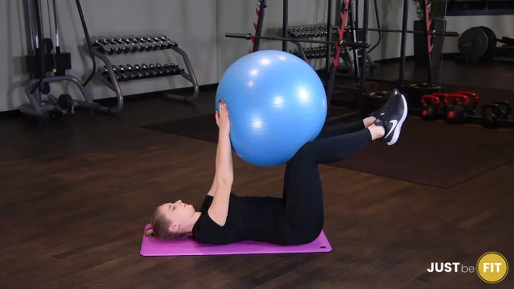 ćwiczenia w domu wciskanie piłki do ćwiczeń w kolana w leżeniu na plecach